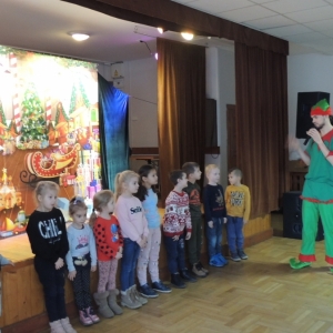 Dzieci stoją pod sceną i pomagają Elfowi